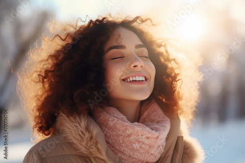 A brunette woman breathes calmly looking up enjoying winter season photo