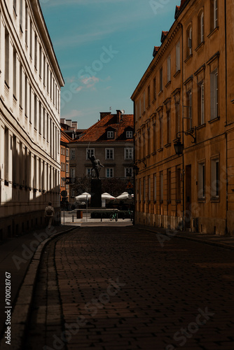 old street in Warsaw Poland dark shadows in a sunny day windows simetrical vertical composition