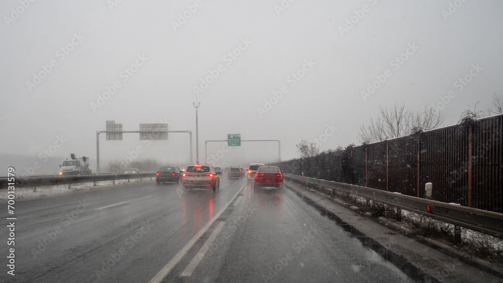 heavy snow during rush hour during snowy foggy winter day in Europe, carefully driving in bad weather condition 