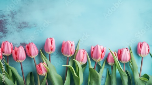 Border of beautiful pink tulips on blue shabby wallpaper background photo