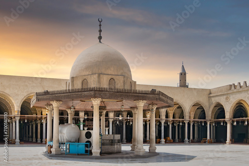 Tanquil courtyard of the Mosque of Amr ibn al-A'as, Egypt's oldest mosque, with sun-drenched dome perched atop the ablution fountain mediationg the courtyard, located in Old Cairo district, aka Fustat photo