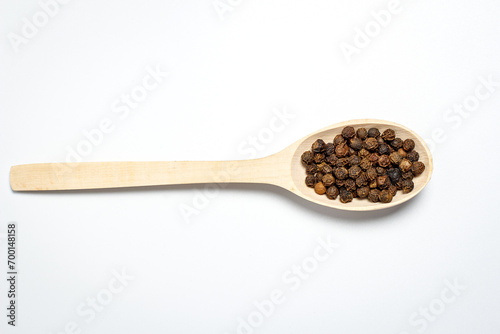 Wooden spoon with spices on a white background
