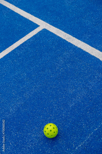 Isolated green pickleball ball in a court © Vic