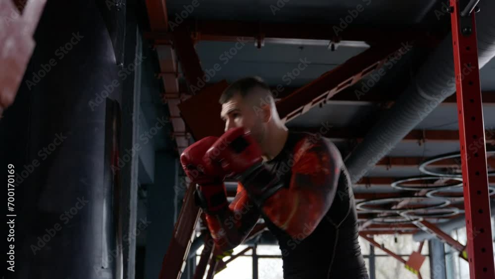 slow motion shot of male boxer hitting a punching bag at a boxing studio. slow motion shot of male boxer hitting a punching bag at a boxing studio.
