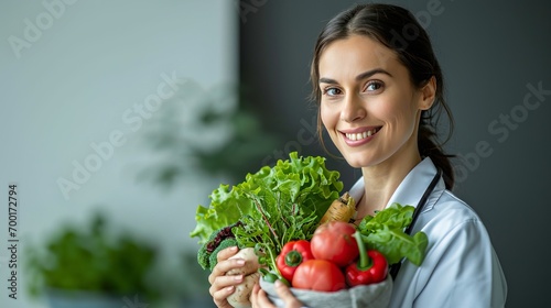 Professional healthcare provider holding fresh vegetables and smiling.