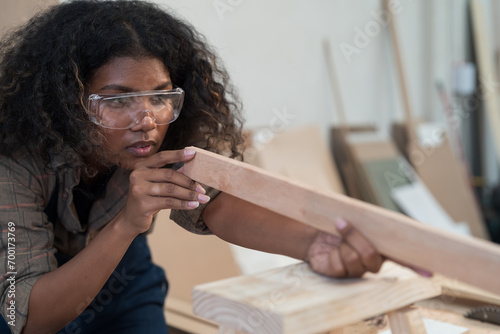 Female carpenter making furniture in factory woodwork. Concept of wood industrial factory