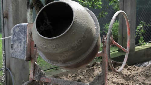Production of a solution of cement mixture for construction. An electric concrete mixer mixes sand, crushed stone, cement and water