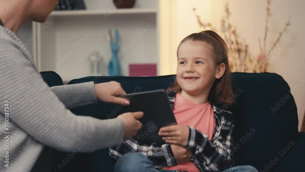 Upset mother struggles to take a gadget away from misbehaving little daughter Upset mother struggles to take a gadget away from misbehaving little daughter