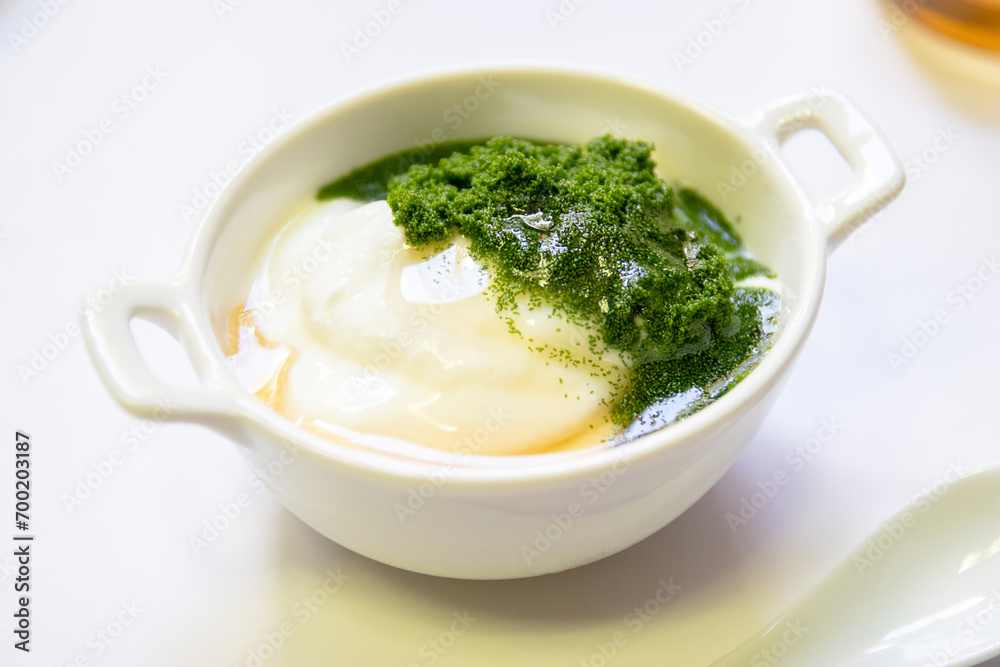 Greek yogurt and wolffia globosa in ceramic bowl isolated on white table background. Wolffia is the nutrient-rich plant-based source of protein and omega3 and vital minerals. Healthy and easy meal. Greek yogurt and wolffia globosa in ceramic bowl isolated on white table background. Wolffia is the nutrient-rich plant-based source of protein and omega3 and vital minerals. Healthy and easy meal.