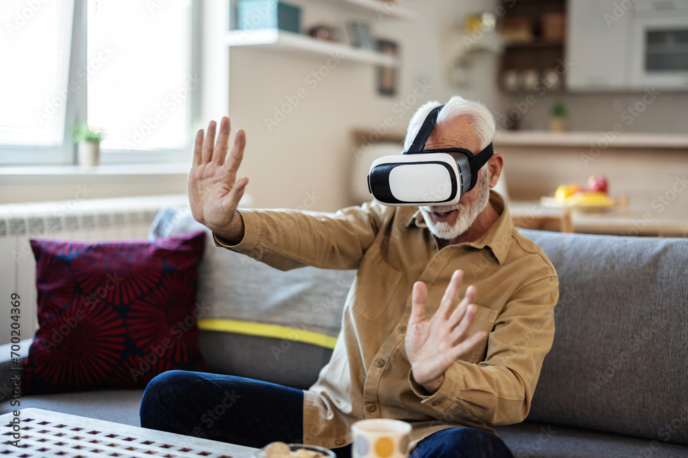 Shot of a mature man using a VR headset at home. Senior man with VR headset. Shot of a mature man using a VR headset at home. Senior man with VR headset.
