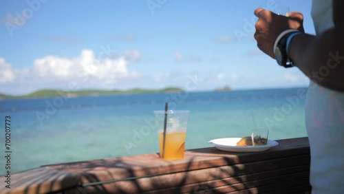 Man eating Caribbean food in front of the sea photo