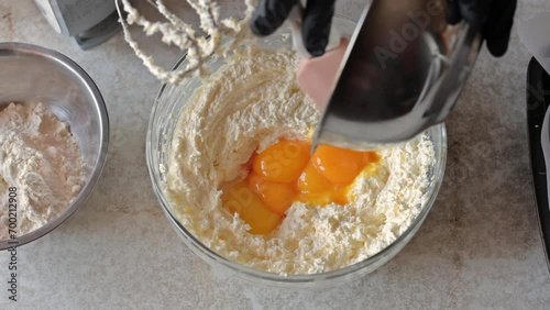 Adding egg yolks to cake batter. Mixing yolks with an electric mixer
