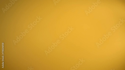Dry raw pasta penne flying diagonally on yellow background in slow motion photo