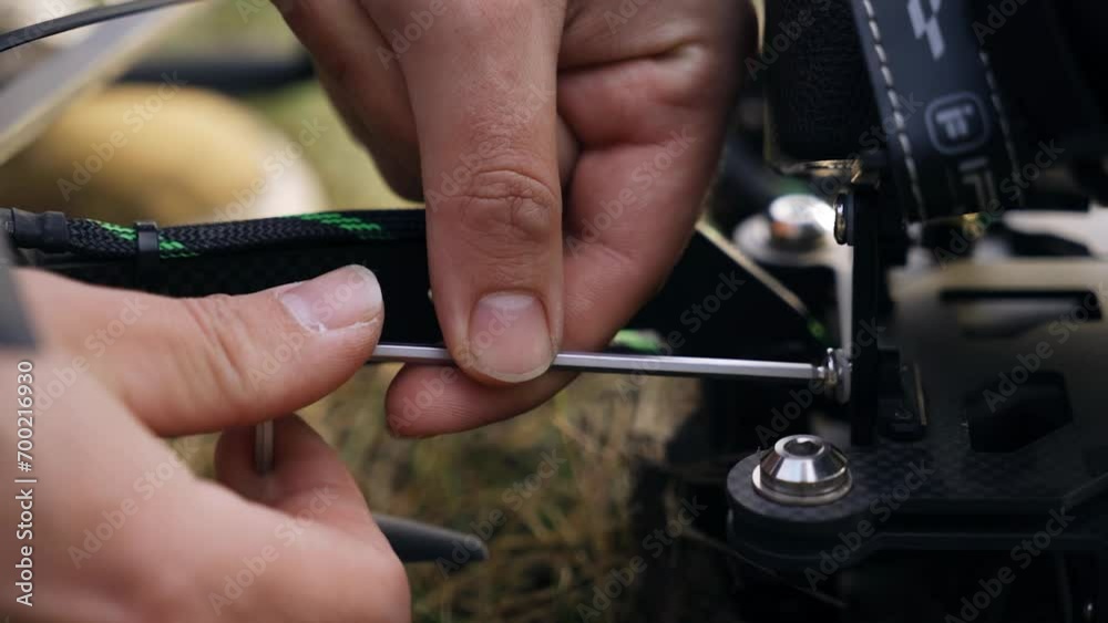 The guy attaches additional devices to the drone using the drone. Close-up of the engineer's hands The guy attaches additional devices to the drone using the drone. Close-up of the engineer's hands