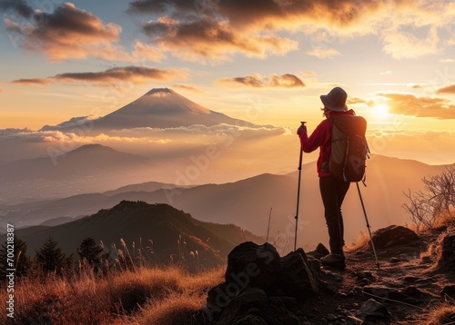 Asian Expedition: A Stunning Woman, Equipped with Trekking Poles, Observes the Beauty of Mount Fuji at Sunset in Japan - A Gorgeous Journey in the Heart of Asia


