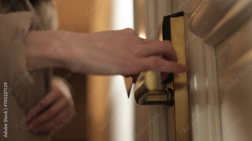 Close up of female hand using plastic contactless key card to open door of hotel room with electronic smart lock. Modern access to apartment with wireless safety technology. Concept of security.