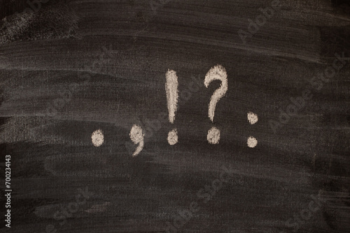 Punctuation marks written in chalk on a blackboard.