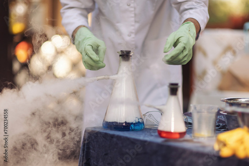 Chemical reaction closeup. Glass flask with puffs of smoke as a result of liquid nitrogen reaction. Nitrogen scientific experiments and show for children. Chemical experiments with dry ice and smoke. photo