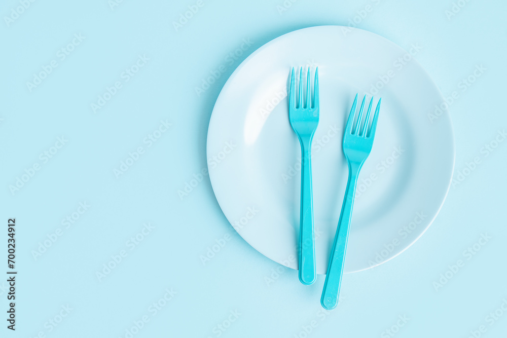 Food concept with children cutlery on blue background Food concept with children cutlery on blue background