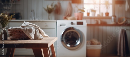 Blurry washing machine and clothes beside wooden table. photo