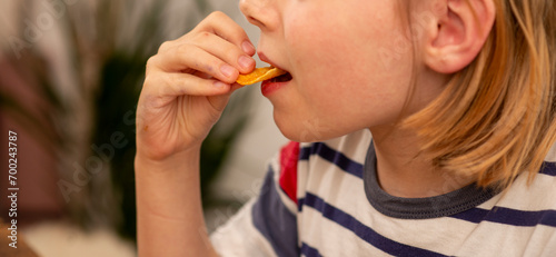 Bilde på lerret boy 10 years old eats chips close up, natural shot