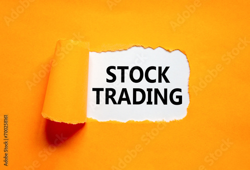 Stock trading symbol. Concept words Stock trading on beautiful white paper. Beautiful orange paper background. Business stock trading concept. Copy space.
