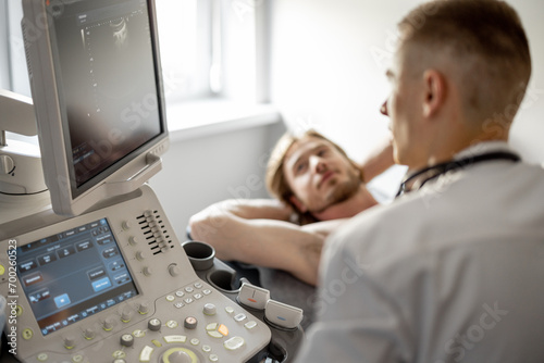 Ultrasound specialist examining lower abdomen of male patient. The concept of ultrasound diagnostics and men's health photo
