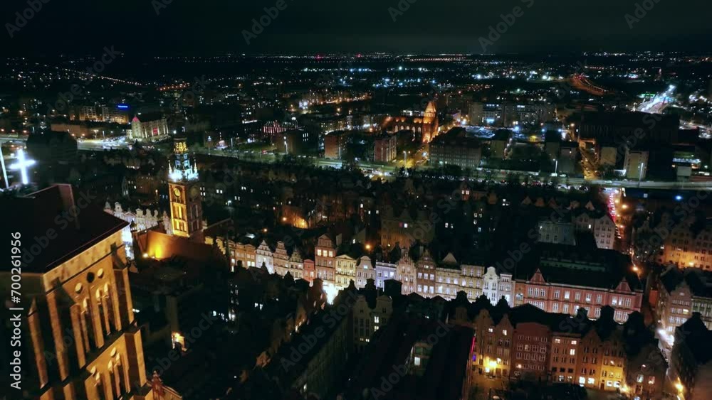 A mesmerizing drone film captures Gdańsk's city center at night in December. Glowing city lights and moving cars create a festive urban scene. A mesmerizing drone film captures Gdańsk's city center at night in December. Glowing city lights and moving cars create a festive urban scene.