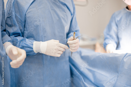 Surgeon holds a surgical tools during an operation, close-up