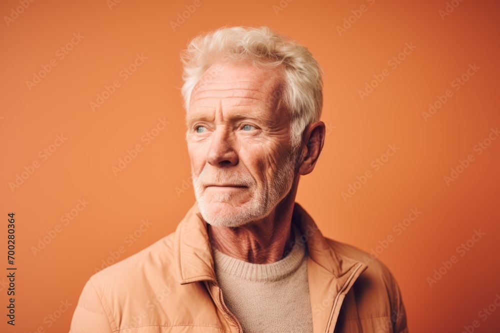 Portrait of an old man on a orange background. Studio shot. Portrait of an old man on a orange background. Studio shot.