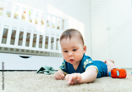 Baby Engaged in Playtime on the Floor. A baby laying on the floor playing with a toy