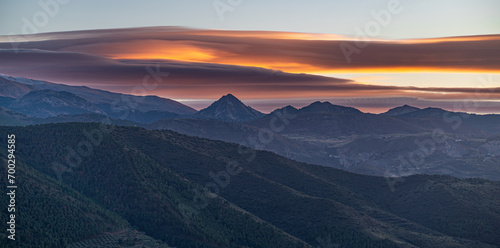 Sunset with spectacular lenticular clouds in the sky over the snowy peaks of Sierra Nevada (Granada, Spain) photo