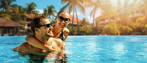 smiling happy couple having fun together in resort swimming pool. summer vacation, getaway travel. banner with copy space