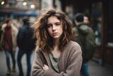 Portrait of young woman with long curly hair in the city.
