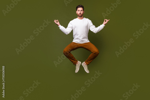 Fotografía Full length photo of calm peaceful man meditating flying air isolated on khaki c