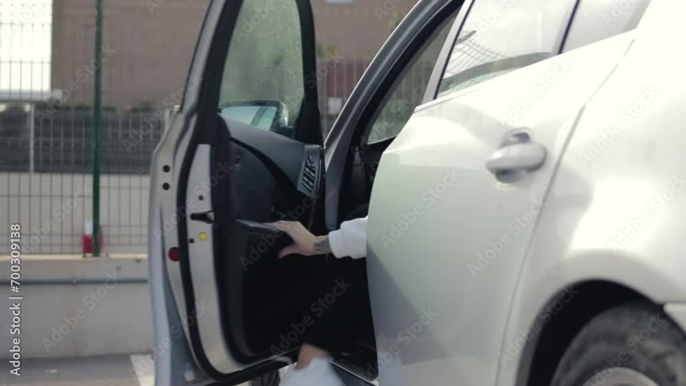 Beautiful woman in casual clothes gets out of a gray car