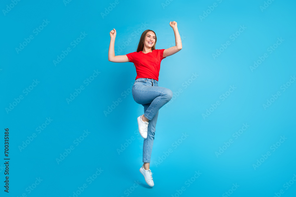 Full length photo of overjoyed cheerful girl wear red stylish outfit looking empty space offer banner isolated on blue color background