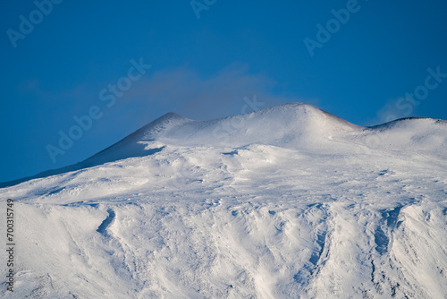 Bronte town under the snowy and majestic volcano Etna and a cloudy blue sky © Wead