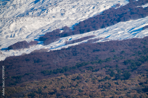 Bronte town under the snowy and majestic volcano Etna and a cloudy blue sky