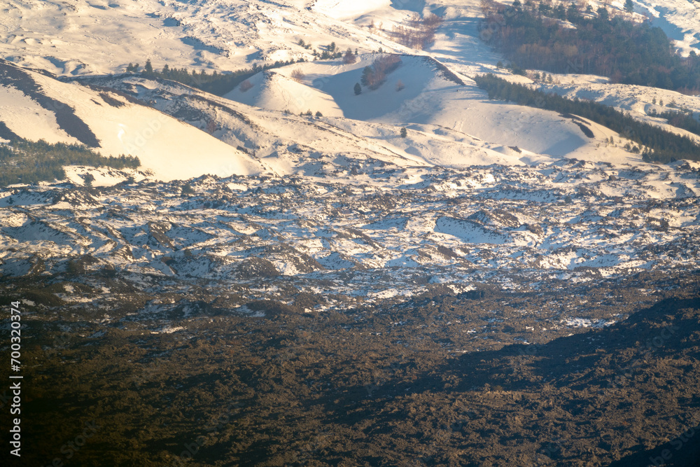 Bronte town under the snowy and majestic volcano Etna and a cloudy blue sky