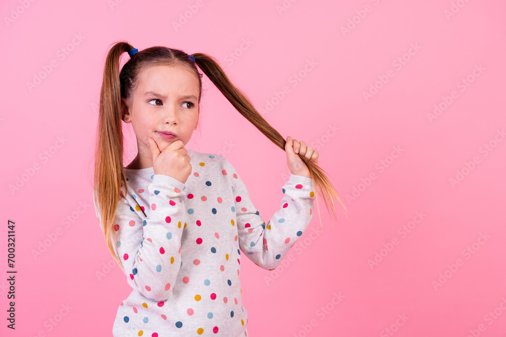 Portrait of pensive schoolgirl with ponytails hairdo dressed dotted sleepwear look empty space hold tail isolated on pink color background Portrait of pensive schoolgirl with ponytails hairdo dressed dotted sleepwear look empty space hold tail isolated on pink color background