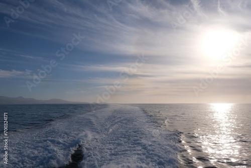 Sufrace of ocean with wake, during cruise ship. Blue sky with clouds ans sun shine. photo