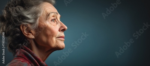 Mature woman with a sad expression, side view, blank area.