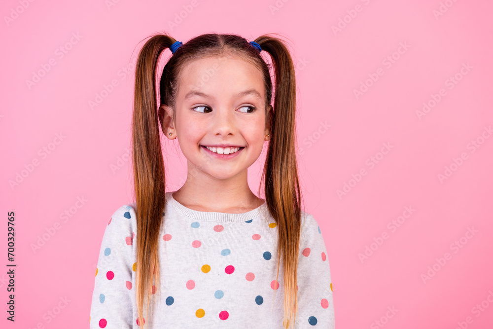 Portrait of lovely schoolgirl with ponytails hairdo dressed dotted sleepwear look at sale empty space isolated on pink color background Portrait of lovely schoolgirl with ponytails hairdo dressed dotted sleepwear look at sale empty space isolated on pink color background