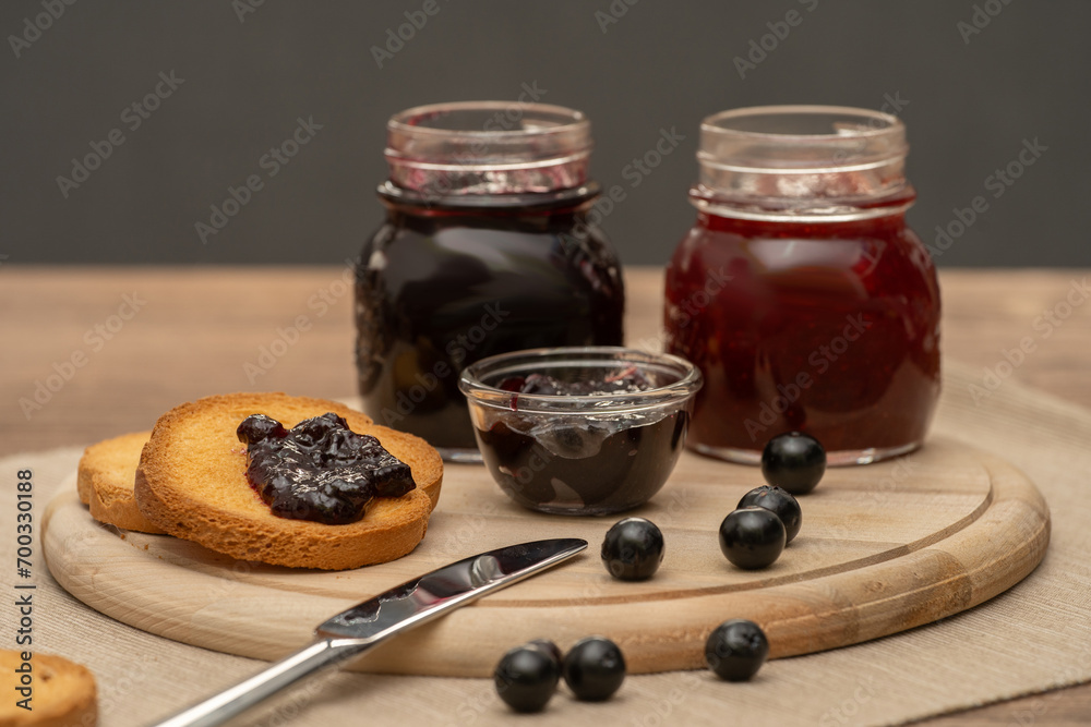 Blueberry jam on wooden plate with knife and bread. Made in Sicily