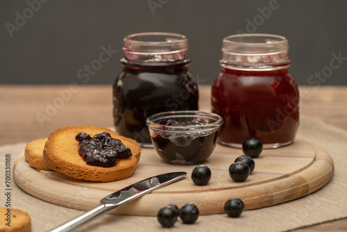 Obraz na płótnie Blueberry jam on wooden plate with knife and bread. Made in Sicily w salonie