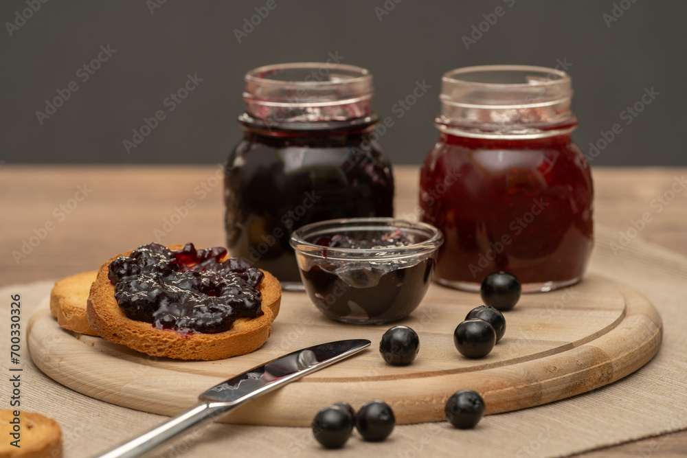 Blueberry jam on wooden plate with knife and bread. Made in Sicily