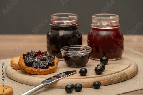 Obraz na płótnie Blueberry jam on wooden plate with knife and bread. Made in Sicily w salonie