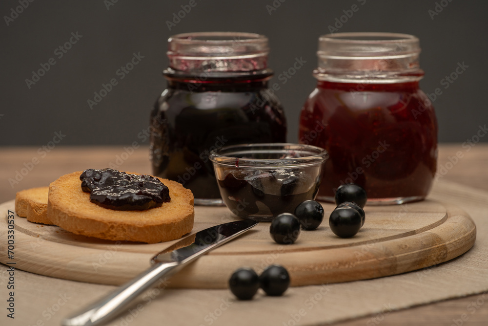 Blueberry jam on wooden plate with knife and bread. Made in Sicily
