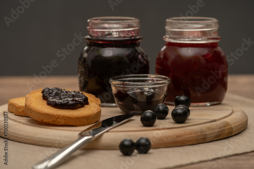 Obraz na płótnie Blueberry jam on wooden plate with knife and bread. Made in Sicily w salonie